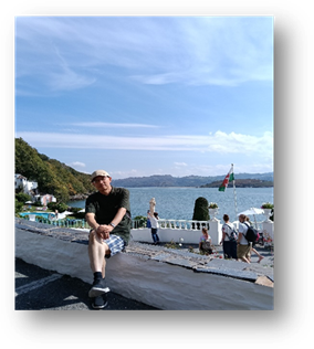 说明: A person sitting on a ledge by a body of water